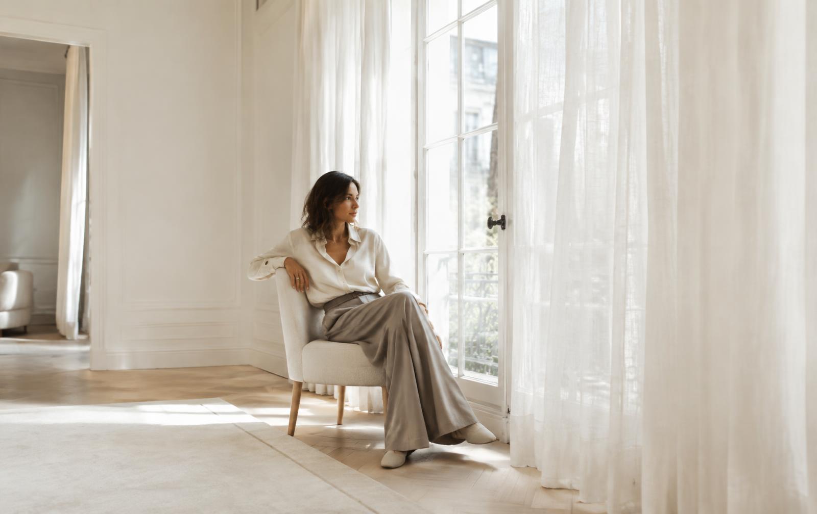 Woman in silk shirt by a window